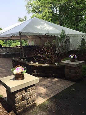 Outdoor area near Clubhouse with tent set up over chairs for wedding or similar event